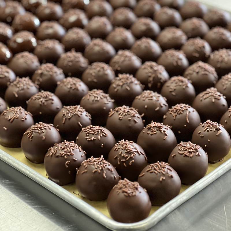 A tray of chocolate truffles covered in sprinkles.